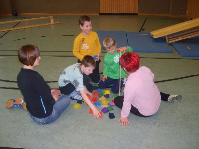 Therapeuten spielen mit Kindern auf dem Boden