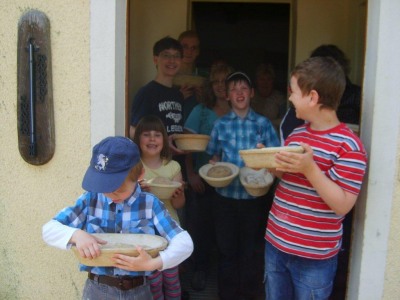 Kinder bringen Brot zum Ofen